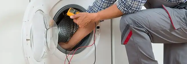 Dryer repair technician inspecting and repairing a clothes dryer in Saint Louis, MO