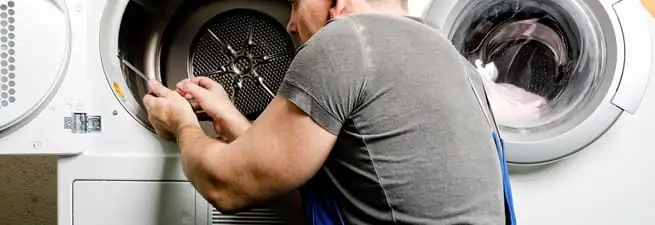 Dryer repair technician fixing a clothes dryer drum in Saint Louis, MO