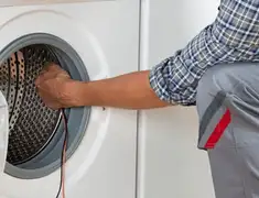 Dryer repair technician diagnosing and servicing a clothes dryer in Saint Louis, MO