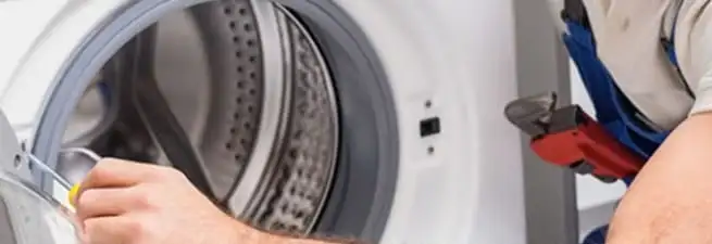 Appliance technician repairing a clothes dryer drum and internal parts in Saint Louis, MO