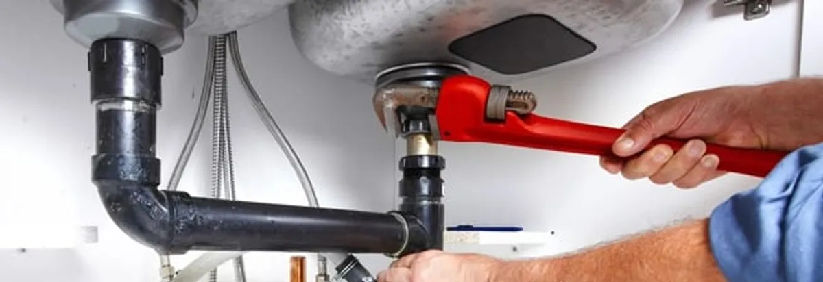 Garbage disposal repair technician tightening the sink drain and disposal connection in Saint Louis, MO