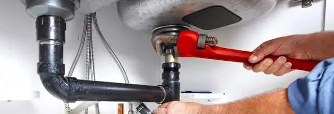 Garbage disposal repair technician tightening the sink drain and disposal connection in Saint Louis, MO