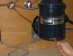 Garbage disposal repair technician tightening the mounting ring under a sink in Saint Louis, MO