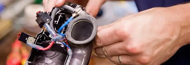 Vacuum repair technician reconnecting wiring and components in Saint Louis, MO