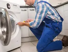 Washing machine repair technician servicing a front-load washer in Saint Louis, MO