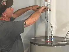 Water heater repair technician tightening supply line connections in Saint Louis, MO