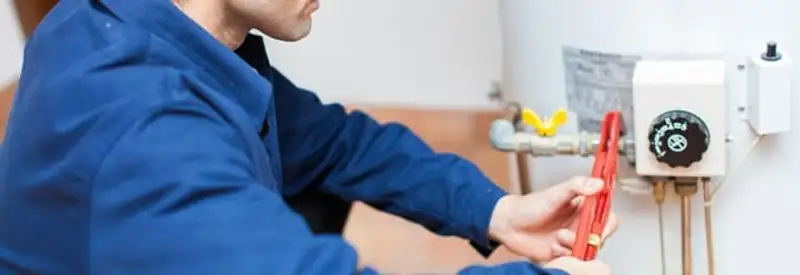Water heater repair technician adjusting the temperature control and gas valve in Saint Louis, MO